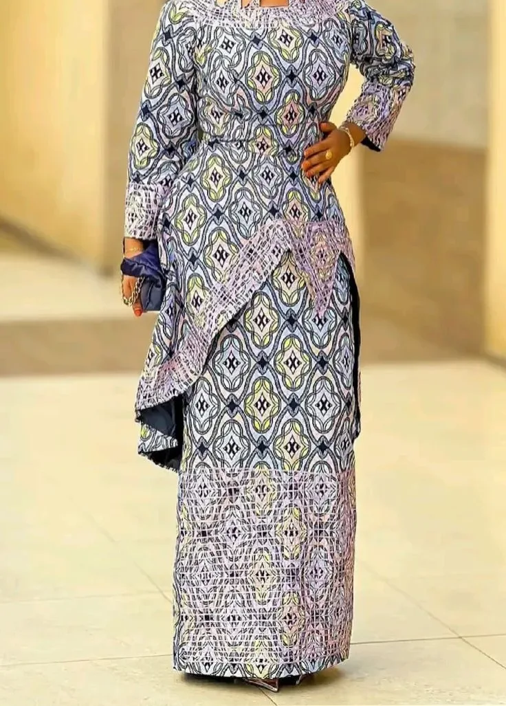 A woman in a grey and lilac Ankara two-piece with a matching gele