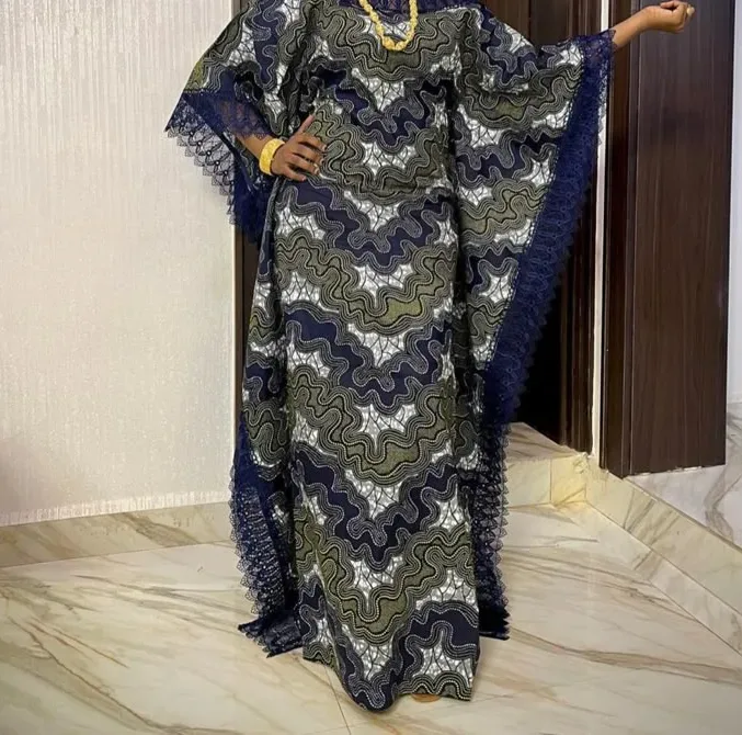 A navy and gold lace boubou with gold beadwork, in a marble interior